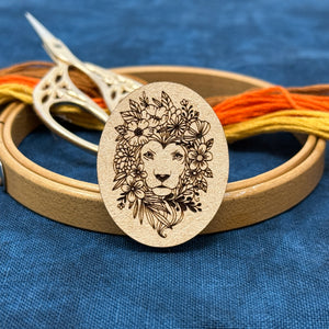 Photo of a needle minder featuring a lion with flowers filling out it's mane.