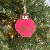 Red hand-painted Creepy Christmas skull bulb ornament hanging on a Christmas tree.