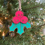 Hand-painted Creepy Christmas Skull Holly Berry laser cut wood ornament hanging on a Christmas tree.